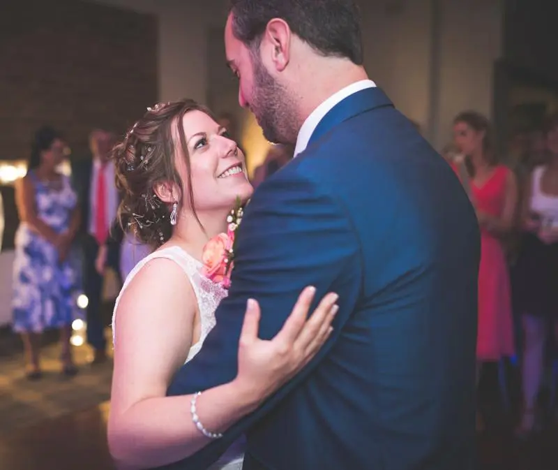 A newlywed couple are dancing, gazing into each other's eyes captured by Dream Capture Wedding Films